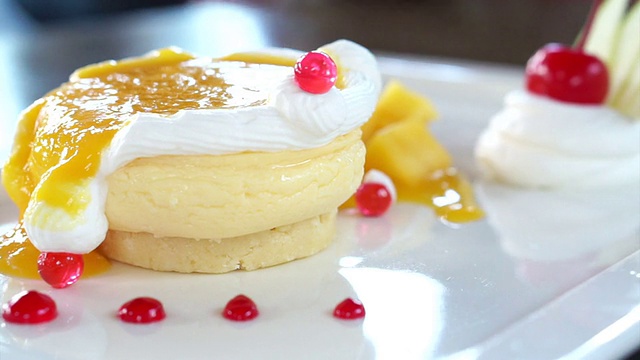 吃着白色的芒果芝士蛋糕，上面点缀着新鲜的水果视频下载
