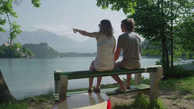 女朋友和男朋友坐在湖边的长椅上视频下载