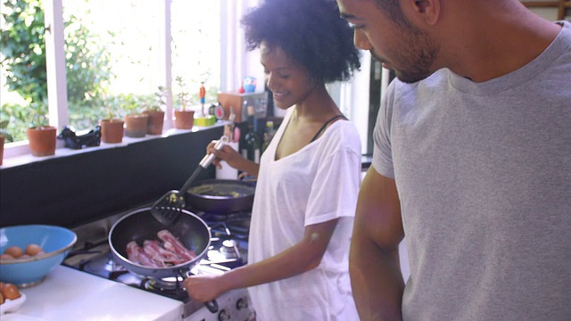 一对年轻夫妇在厨房里一起做早餐视频素材