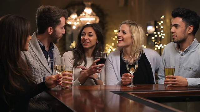 一群朋友在酒吧享受晚上的饮料视频素材