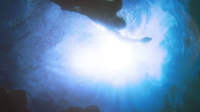 慢动作游泳男子的剪影与阳光从底部摄像机视频素材