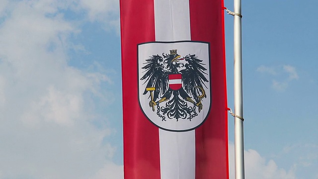 奥地利国旗和徽在风中飘扬，蓝天为背景视频下载