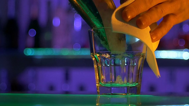 调酒师在吧台做鸡尾酒在黑暗中，烈酒，近距离，慢动作视频下载