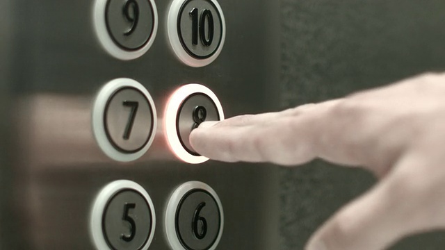 一个男人在八楼的电梯里按了一个按钮视频素材