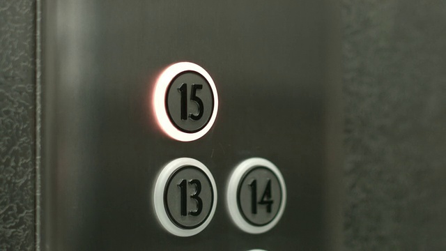 一个男人在电梯里按下了15楼的按钮视频素材
