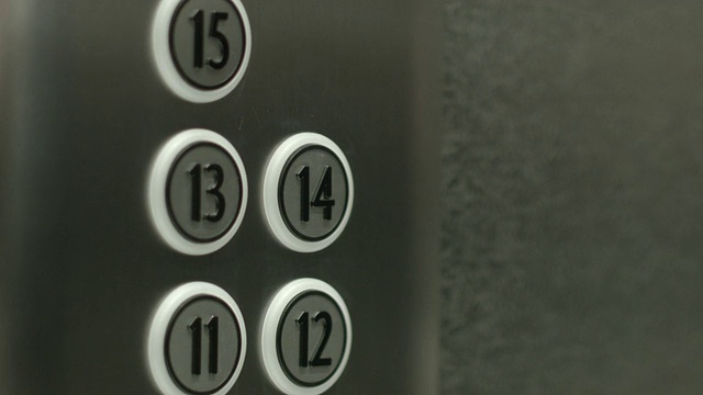 一个男人在电梯里按下了十四楼的按钮视频素材