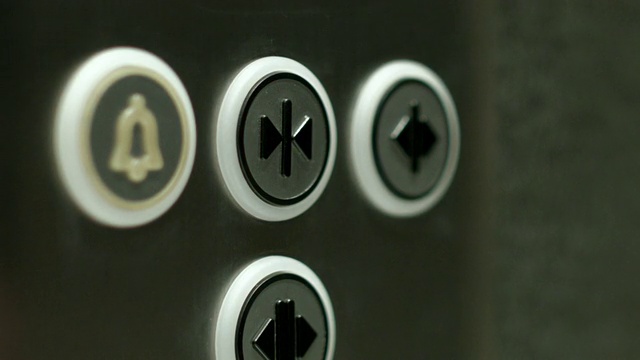 一名男子按下按钮关闭电梯门。近距离视频下载