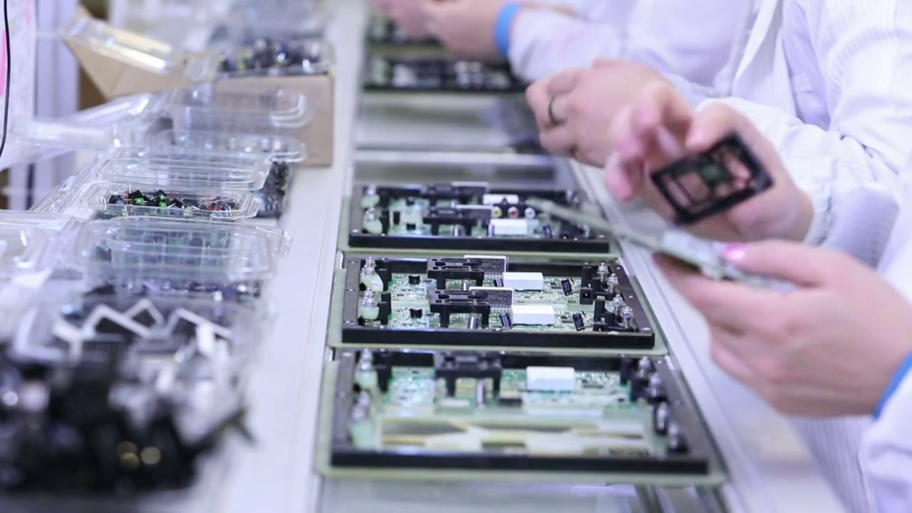 工人们在电子厂生产电路板-装配线led，晶体管和其他电子组件正在安装视频素材