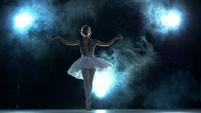年轻美丽的舞者在蓝色的背景下摆姿势视频素材