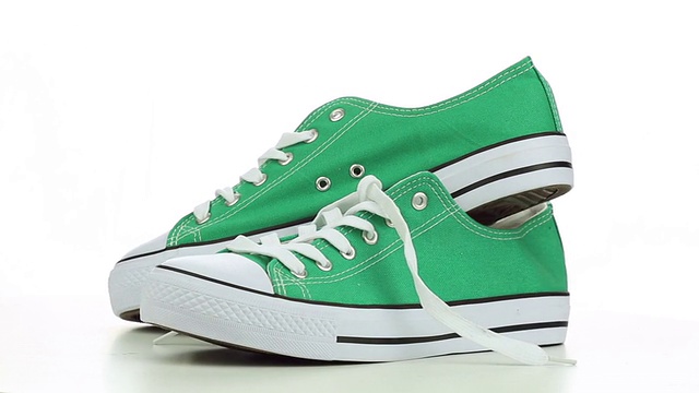 绿色的运动鞋在白色的背景上旋转视频下载