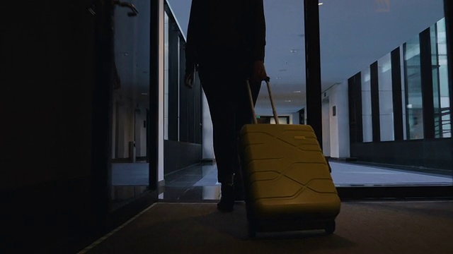 一个女人拿着旅行袋走向她的酒店房间视频素材
