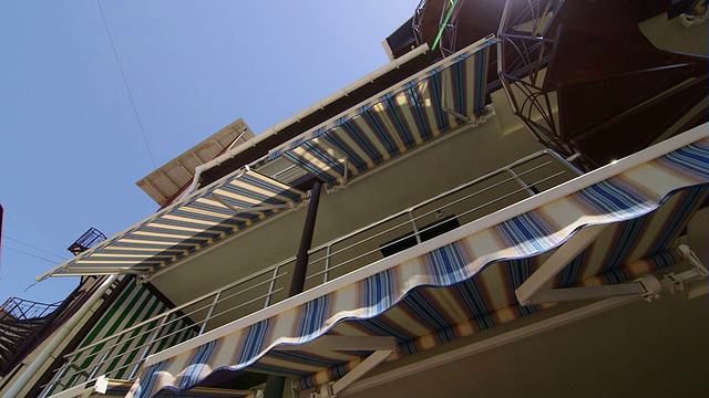 酒店前面有可伸缩的条纹遮阳篷和螺旋楼梯视频素材