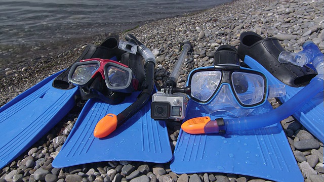 野生卵石滩上的两套浮潜装置和水下数码相机视频下载