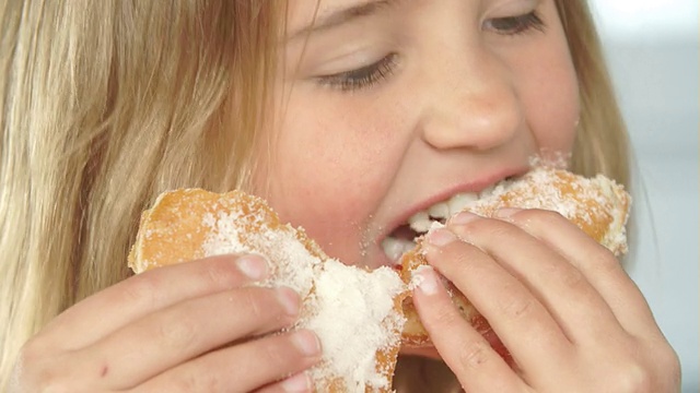 女孩吃甜甜甜圈的特写视频素材