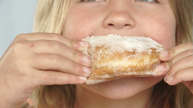 女孩吃甜甜甜圈的特写视频素材
