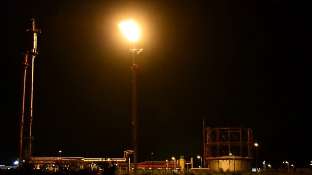 炼油厂塔火炬在夜间燃烧疏散气体视频下载