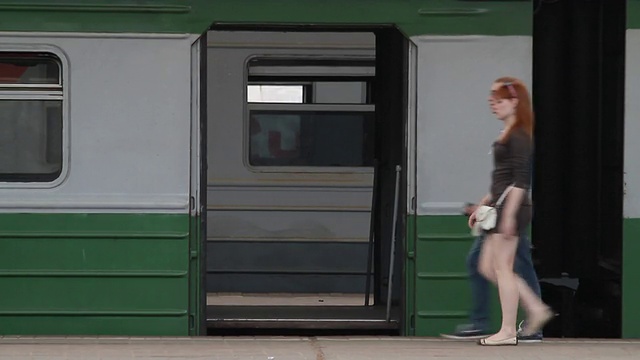 乘客们在站台上，在列车敞开的车门的背景上视频下载