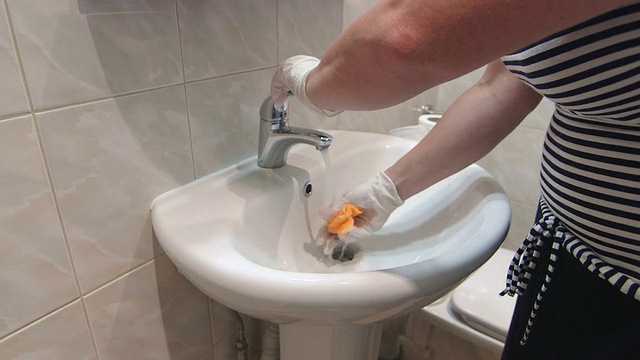 一个女人用超细纤维布擦拭浴室的水槽视频素材