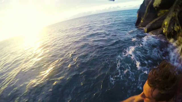 两个年轻人从悬崖上跳入大海视频素材