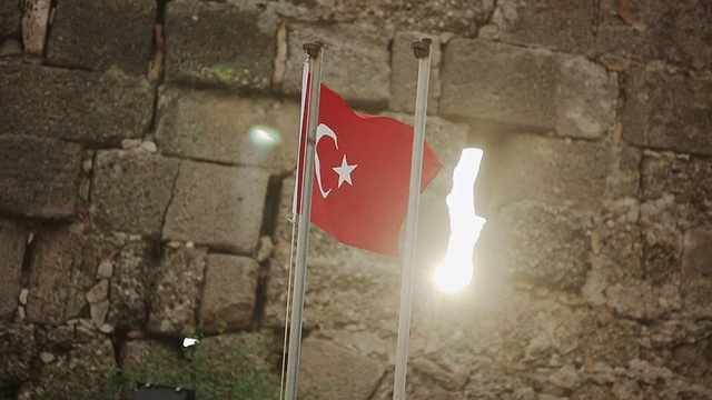 日落时分，一面土耳其国旗挂在石墙上视频下载