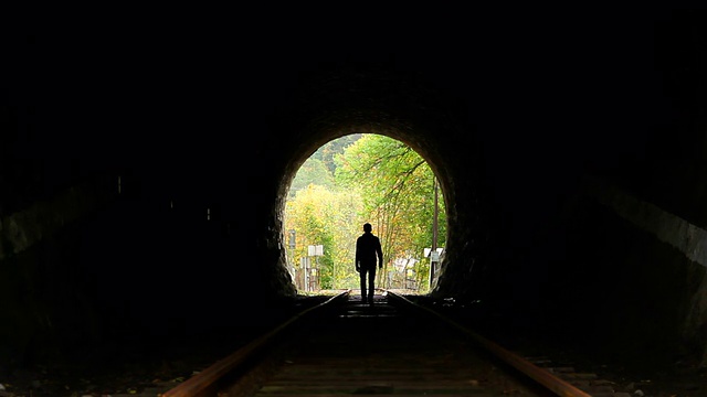 人走在隧道里，黑色的剪影，寻找出路视频素材