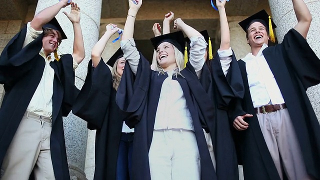 快乐的毕业生举起了他们的手臂视频素材