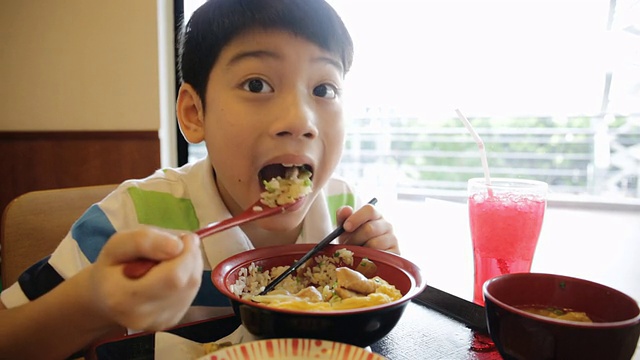 快乐的亚洲男孩吃日本午餐套装视频素材