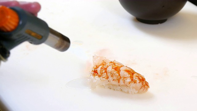 寿司厨师用厨房手电筒烹饪虾视频素材