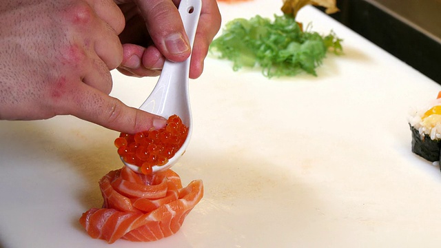 寿司厨师准备鲑鱼和鱼子酱刺身花视频素材