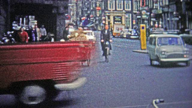 德国科隆——1966年:一个穷人骑着自行车穿过城市，带着大量不知名的商品。视频素材