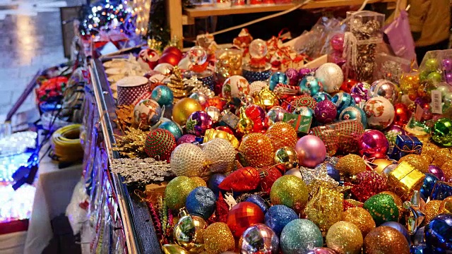 从左到右的一个圣诞市场和一张满是彩色装饰球的桌子的移动镜头视频下载