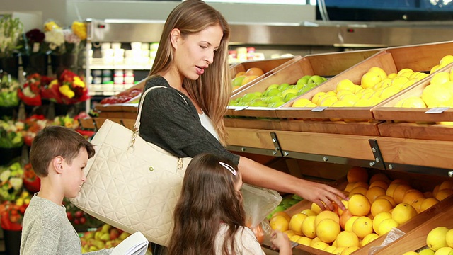 母亲和孩子们在超市挑选水果视频素材