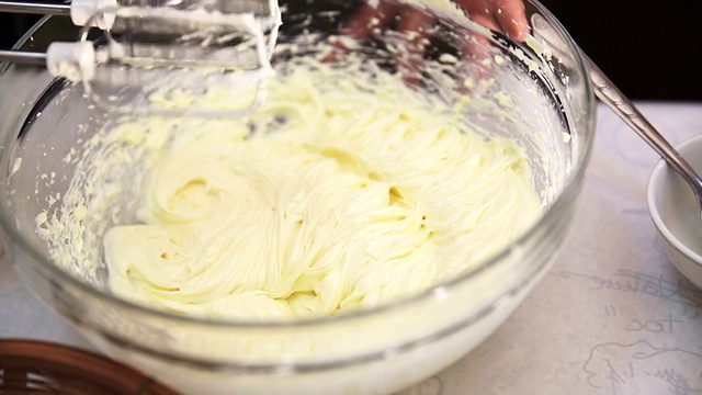 用搅拌器将糖和奶油搅打到奶酪中，制成芝士蛋糕甜点视频素材