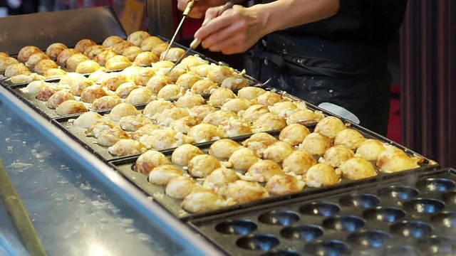 烹饪章鱼烧日本章鱼粉丸子。传统的日本小吃视频素材