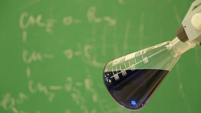 焦点从旋转的蓝色烧瓶到写在绿色板上的化学公式视频下载