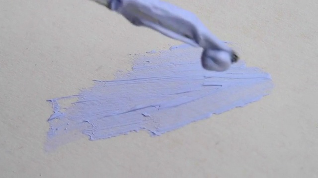 小刷子用蓝色颜料在画布上画特写视频素材
