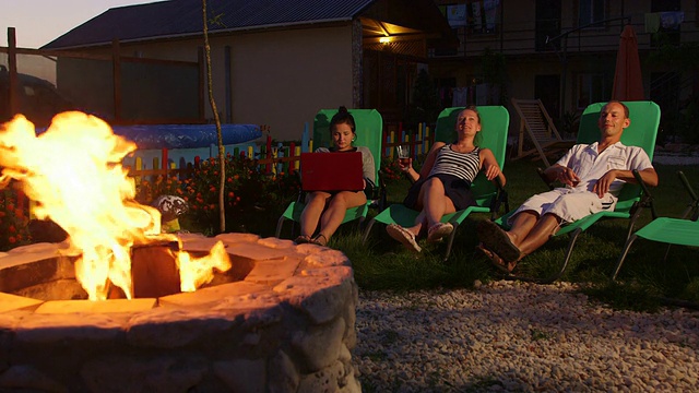 黄昏时分，人们坐在院子里的火坑旁放松视频素材