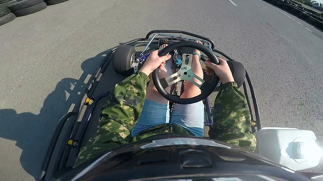 卡丁车女车手冲在卡丁车赛道上，头盔上安装了摄像头视频下载