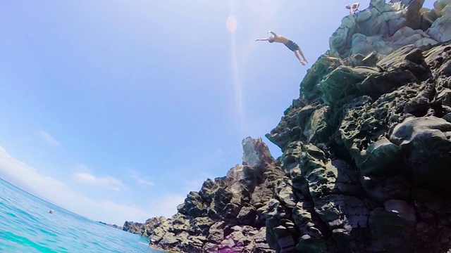 极高的POV后空翻悬崖跳入水中的慢动作视频素材