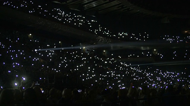 在体育场看台上用灯照明的人们视频素材