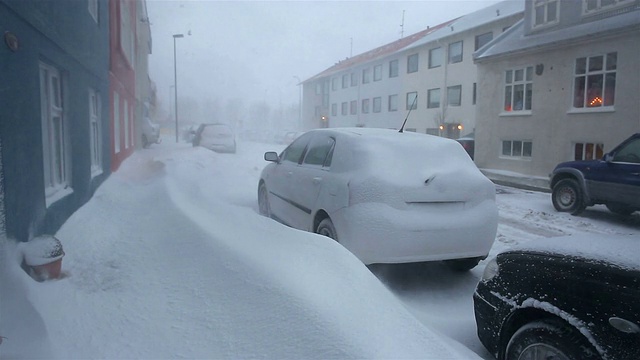 厚厚的积雪堵塞了人行道，淹没了居民区的汽车视频素材