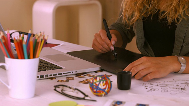 图形设计师在她的办公桌上使用数字化仪视频素材