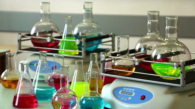 彩色实验室玻璃器皿上的摇瓶和桌子集中在前面视频下载