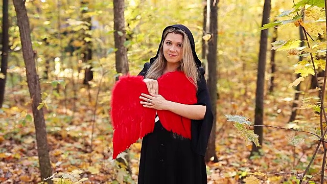 森林里长着红色天使翅膀的美丽女孩视频素材