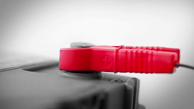 跨接电缆夹连接到死(或充电)电池;只有红色的夹子是彩色的。视频素材