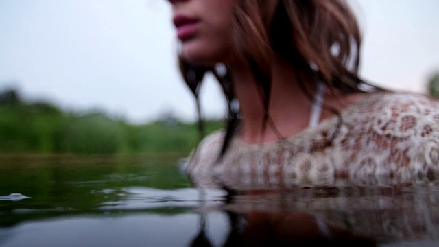 嬉皮女孩在自然湖中盯着你看视频素材