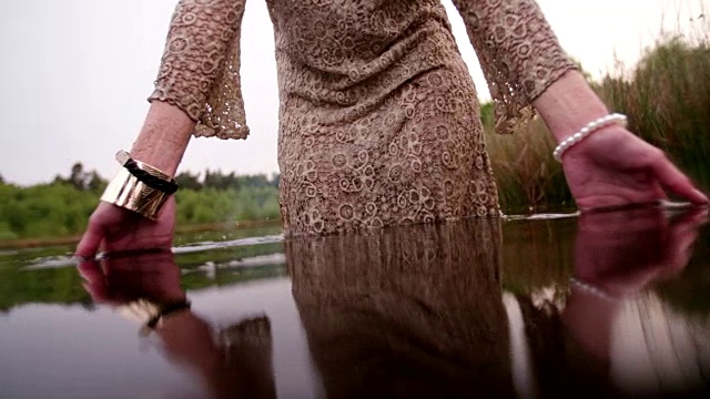 嬉皮女孩穿着蕾丝裙站在湖里视频素材