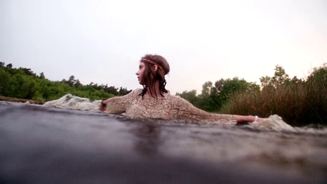 嬉皮女孩穿着蕾丝裙站在湖里视频素材