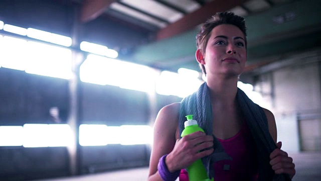 女人在锻炼中拿着水瓶休息视频素材