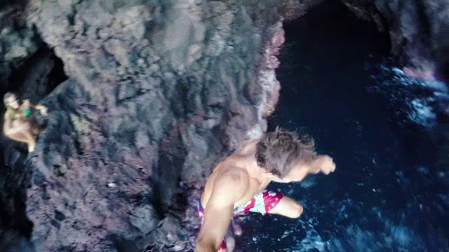 慢动作GOPRO POV年轻人悬崖跳进海洋。有问题把视频素材